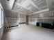 Living room featuring a tray ceiling, custom shelving, cabinetry, large windows, and unfinished walls at 839 Braselton Hwy, Lawrenceville, GA 30043