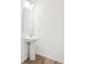 Simple half-bath featuring a pedestal sink with modern fixtures and a minimalist design at 7260 Eton Ln, Locust Grove, GA 30248