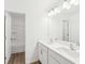 Modern bathroom featuring double sinks with white cabinets and a large mirror at 7260 Eton Ln, Locust Grove, GA 30248