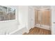 Bathroom featuring a soaking tub, walk-in shower, and wood-style flooring at 7260 Eton Ln, Locust Grove, GA 30248