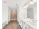 Bathroom featuring a double vanity, walk-in shower, and wood-style flooring at 7260 Eton Ln, Locust Grove, GA 30248