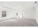 Spacious bedroom with neutral carpet, tray ceiling, and two windows at 7260 Eton Ln, Locust Grove, GA 30248