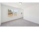 Bright bedroom featuring neutral carpet, white walls, and a large window at 7260 Eton Ln, Locust Grove, GA 30248