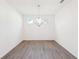 Empty dining area with hardwood floors, a modern chandelier, and three windows at 7260 Eton Ln, Locust Grove, GA 30248