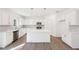 Modern kitchen with sleek white cabinetry, stainless steel appliances, and an island that serves as a breakfast bar at 7260 Eton Ln, Locust Grove, GA 30248