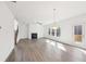 Open-concept living room with hardwood floors, fireplace, and access to the deck via a glass door at 7260 Eton Ln, Locust Grove, GA 30248
