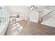 Bright, open-concept living area with hardwood floors, leading into a modern kitchen and staircase at 7260 Eton Ln, Locust Grove, GA 30248