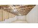 Unfinished basement with concrete walls and exposed trusses at 7260 Eton Ln, Locust Grove, GA 30248