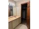 Bathroom with white vanity, mirror, and open closet at 3557 Clubhouse Ln, Conyers, GA 30094