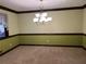Dining room featuring elegant chandelier, neutral carpeting and wainscoting at 3557 Clubhouse Ln, Conyers, GA 30094
