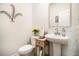 Elegant bathroom with pedestal sink, toilet and decorative wall accents at 7787 Richmond Trl, Fairburn, GA 30213