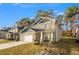 Two-story house with stone and gray siding, two-car garage, and a landscaped yard at 7787 Richmond Trl, Fairburn, GA 30213
