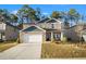 Two-story house with stone and gray siding, a two-car garage, and a landscaped yard at 7787 Richmond Trl, Fairburn, GA 30213