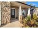 Front entry with stone facade, black door, and small porch at 7787 Richmond Trl, Fairburn, GA 30213