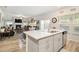 Open concept kitchen with island, gray cabinets, and views into living room at 7787 Richmond Trl, Fairburn, GA 30213