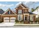 Brick front home with 3-car garage, landscaping, and charming curb appeal at 3175 Weston Nw Pl, Atlanta, GA 30327