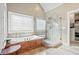Luxurious bathroom featuring a soaking tub, walk-in shower, and a linen closet at 2041 Democracy Dr, Buford, GA 30519