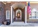 Elegant entryway with arched columns, stonework, and a wood door at 2041 Democracy Dr, Buford, GA 30519