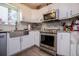 Bright kitchen features white cabinets, stainless steel appliances, and a farmhouse sink at 706 Berry Ct, Villa Rica, GA 30180