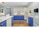 Stylish kitchen featuring blue lower cabinets, white upper cabinets, stainless appliances, and hardwood floors at 125 Hillcrest Trce, Fayetteville, GA 30215