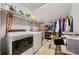 Efficient laundry room featuring a washer and dryer, shelving, and clothing storage on racks at 125 Hillcrest Trce, Fayetteville, GA 30215