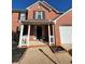 Home exterior showcasing the well-maintained front porch and attached two car garage at 575 Dunagan Dr, Lawrenceville, GA 30045