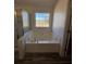 Bright main bathroom features a large soaking tub and walk-in shower at 575 Dunagan Dr, Lawrenceville, GA 30045