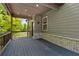 Spacious covered back porch, showcasing the home's green exterior and outdoor living space at 4002 Adler Cir, Buford, GA 30519