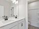 Bright bathroom with dual sinks, black faucets, undermount sinks, and tiled flooring at 4002 Adler Cir, Buford, GA 30519