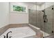Bathroom with soaking tub, glass shower, and window at 4002 Adler Cir, Buford, GA 30519