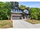 Charming two-story home featuring stone and siding exterior, manicured lawn and attached two-car garage at 4002 Adler Cir, Buford, GA 30519