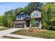 Charming two-story home featuring stone and siding exterior, manicured lawn and attached two-car garage at 4002 Adler Cir, Buford, GA 30519