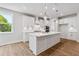Spacious kitchen with white cabinetry, large center island, pendant lights, and quartz countertops at 4002 Adler Cir, Buford, GA 30519