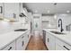 Modern kitchen with white cabinets, quartz countertops, stainless steel appliances, and hardwood flooring at 4002 Adler Cir, Buford, GA 30519