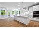Modern kitchen with white cabinets, stainless steel appliances, large island, and hardwood floors at 4002 Adler Cir, Buford, GA 30519