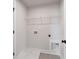 Efficient laundry room with tile floor and white wire shelf at 4002 Adler Cir, Buford, GA 30519