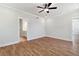 Spacious main bedroom featuring wood-look flooring, ceiling fan, and a ensuite bathroom entrance at 4002 Adler Cir, Buford, GA 30519