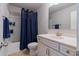 Bathroom features a vanity with a white countertop, a toilet, and shower with blue curtain at 5915 Partners Pass, Cumming, GA 30028