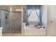 Elegant bathroom featuring a soaking tub beneath a window and a glass enclosed shower at 5915 Partners Pass, Cumming, GA 30028
