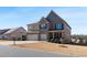 Inviting two-story home with brick and siding, three-car garage, and landscaped front yard on a sunny day at 5915 Partners Pass, Cumming, GA 30028