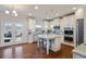 Modern white kitchen featuring stainless steel appliances, an island, and access to the backyard at 5915 Partners Pass, Cumming, GA 30028