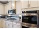 Close-up of stainless steel microwave and oven, with granite countertops, and tiled backsplash at 5915 Partners Pass, Cumming, GA 30028