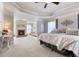 Main bedroom with fireplace, chaise lounge, and luxurious neutral decor at 5915 Partners Pass, Cumming, GA 30028