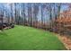Large grassy backyard with wooded area and fence at 221 Oakwood Dr, Cumming, GA 30040