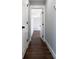 Hallway with dark wood flooring leading to other rooms with white doors and light gray walls at 4187 Mistymorn Way, Powder Springs, GA 30127
