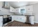Well-lit kitchen featuring stainless steel appliances, sleek white cabinetry, and dark countertops at 4187 Mistymorn Way, Powder Springs, GA 30127