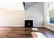 Bright living room featuring hardwood floors, a cozy fireplace, and a large window at 4187 Mistymorn Way, Powder Springs, GA 30127