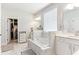 Spa-like bathroom with soaking tub, double vanity, and marble tile at 445 Carmichael Cir, Canton, GA 30115