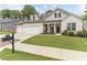 Two-story house with gray siding, three-car garage, and landscaped yard at 445 Carmichael Cir, Canton, GA 30115