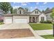 Brick house with 3-car garage and manicured lawn at 445 Carmichael Cir, Canton, GA 30115